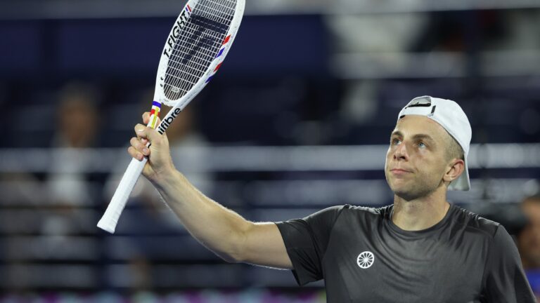 ATP player holds up racquet to acknowledge the crowd