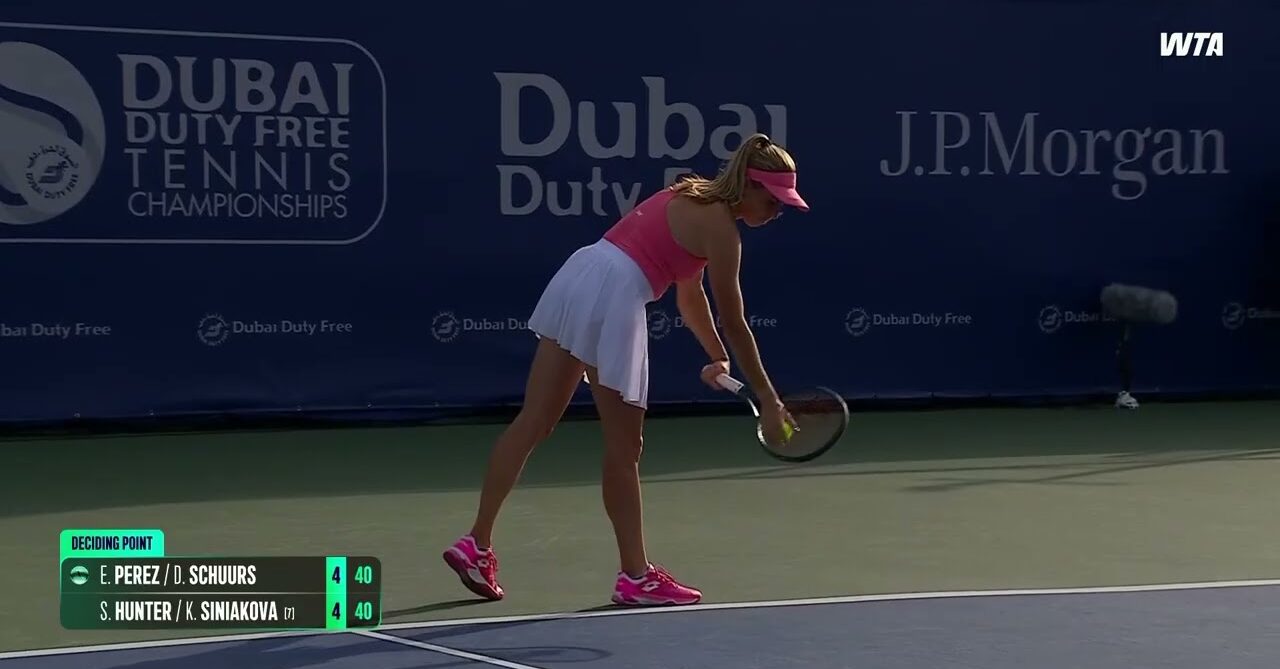 WTA tennis player prepares to serve during doubles match